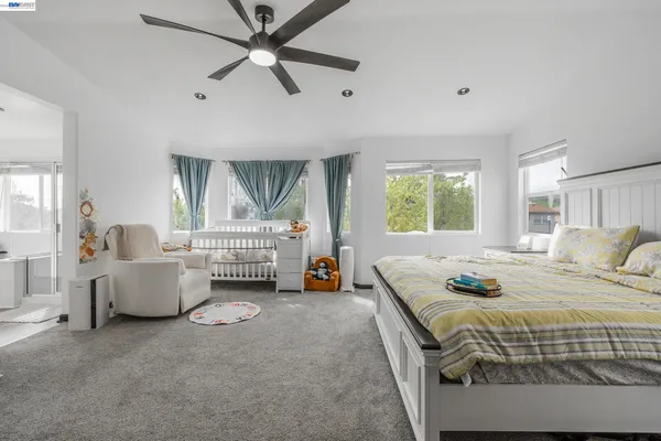 a bedroom with a bed a window and television