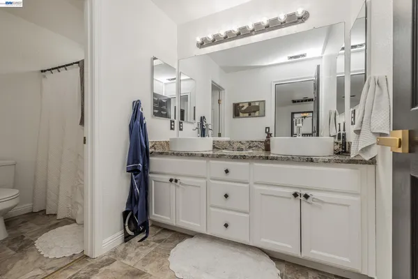 a bathroom with a granite countertop sink toilet and shower