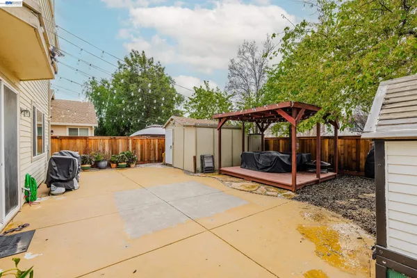 a backyard of a house with barbeque oven table and chairs