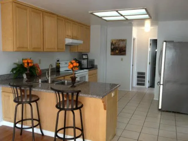 a kitchen with stainless steel appliances granite countertop a refrigerator and a stove top oven