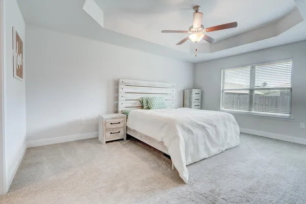 a bedroom with a large bed and a ceiling fan