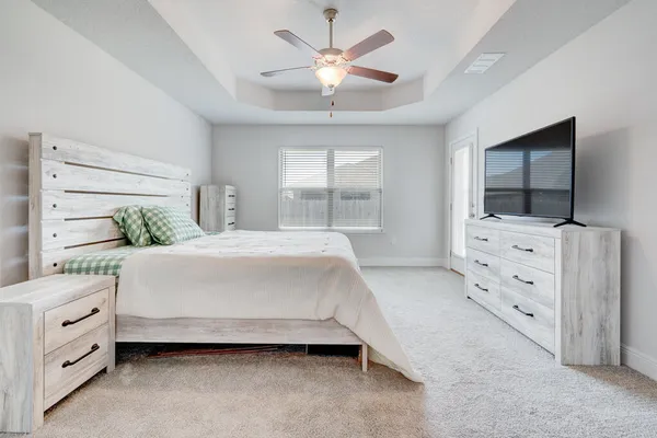 a spacious bedroom with a bed and a flat screen tv