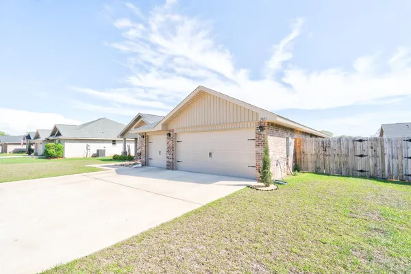 a view of house with backyard and glass windows