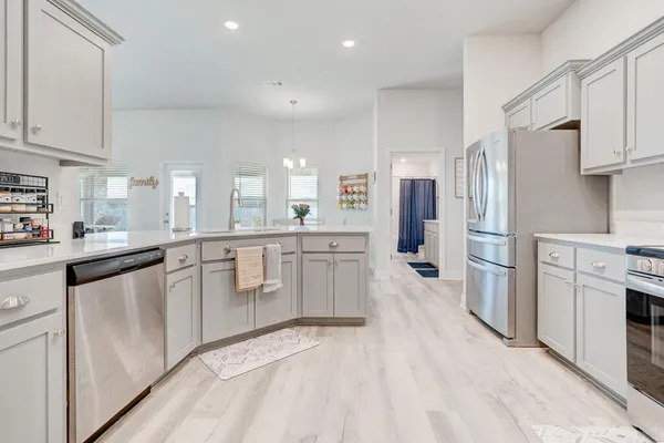 a kitchen with white cabinets and stainless steel appliances