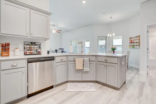 a kitchen with white cabinets and sink