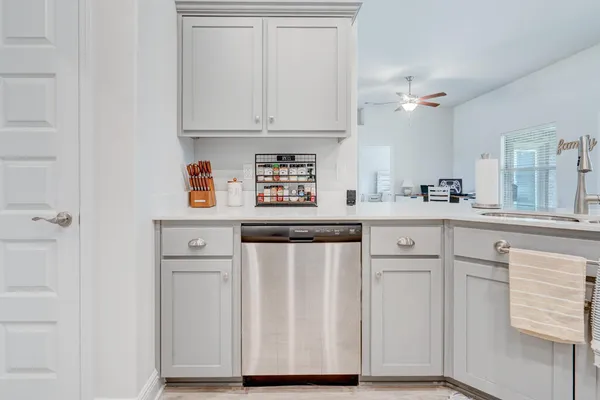 a kitchen with white cabinets and sink