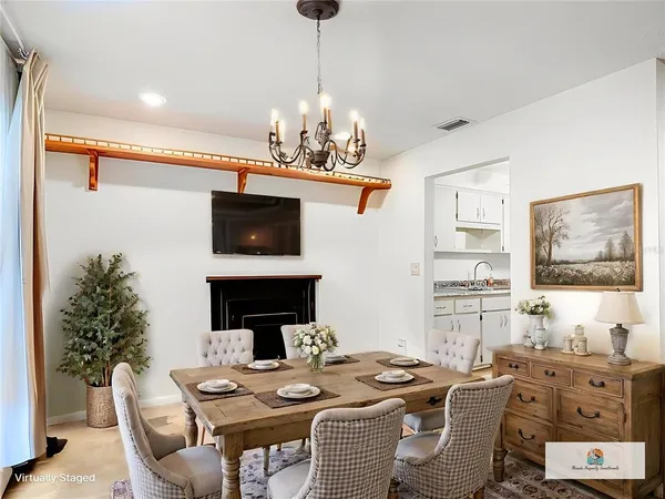 a view of a dining room with furniture a chandelier and wooden floor