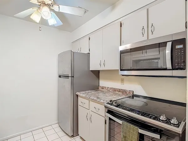a kitchen with granite countertop a stove microwave and refrigerator