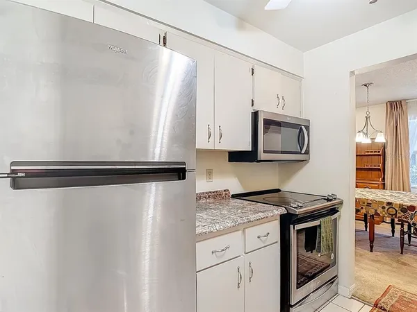 a kitchen with granite countertop a refrigerator stove and microwave