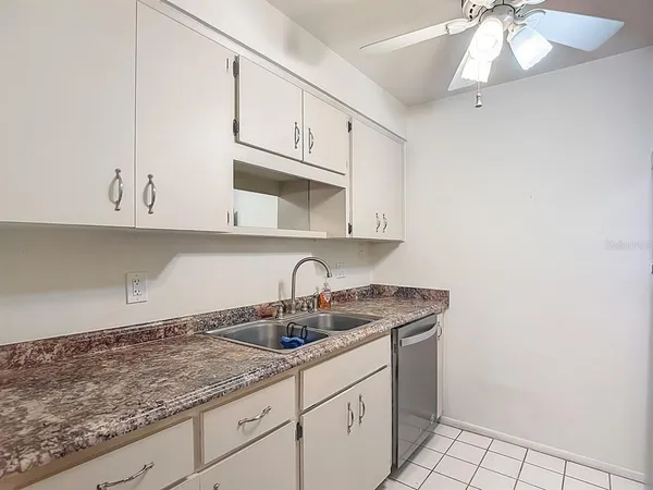 a kitchen with white cabinets a sink and dishwasher