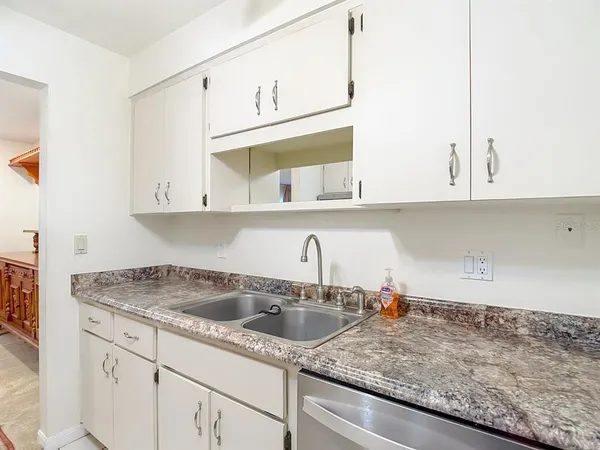 a kitchen with stainless steel appliances granite countertop white cabinets sink and dishwasher