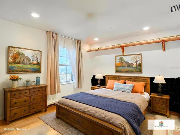 a bedroom with a bed and wooden floor