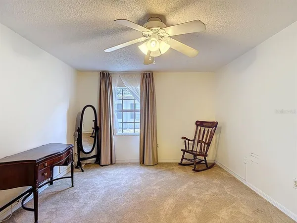 an empty room with windows and fan