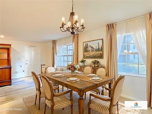 a view of a dining room with furniture a chandelier and wooden floor