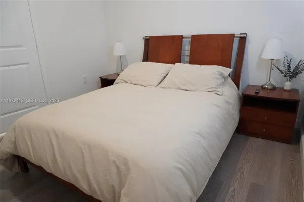 a bedroom with bed and wooden floor