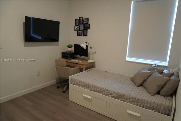 a bedroom with a bed and a flat screen tv