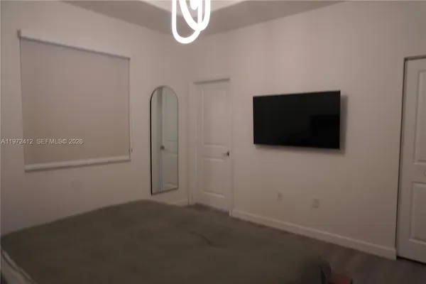 a view of a livingroom with an empty space and a flat screen tv