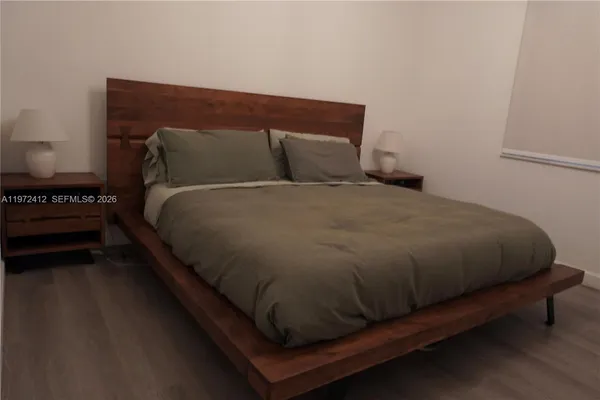 a bed sitting in a bedroom next to a lamp
