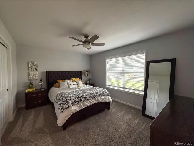 a bedroom with a bed a chandelier and a window