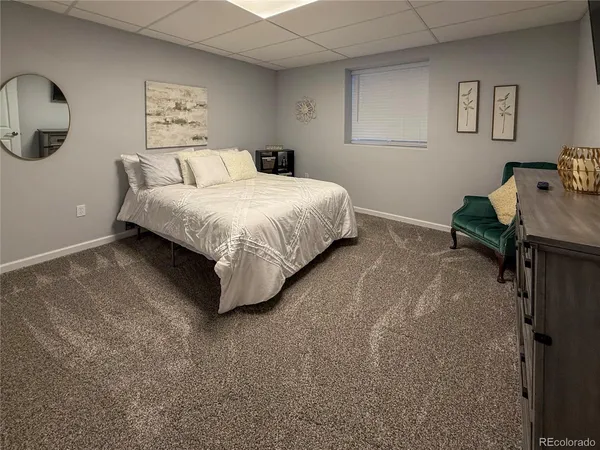 a bedroom with a bed and painting on the wall