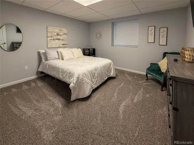 a bedroom with a bed and painting on the wall