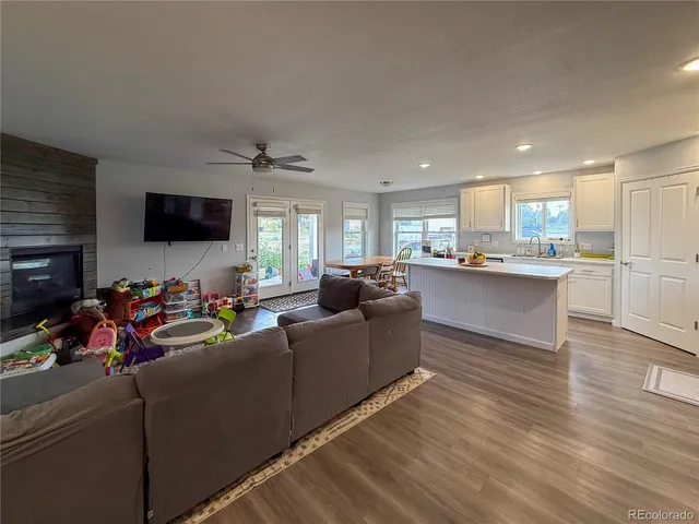 a kitchen with kitchen island granite countertop a stove top oven a sink a counter space and cabinets