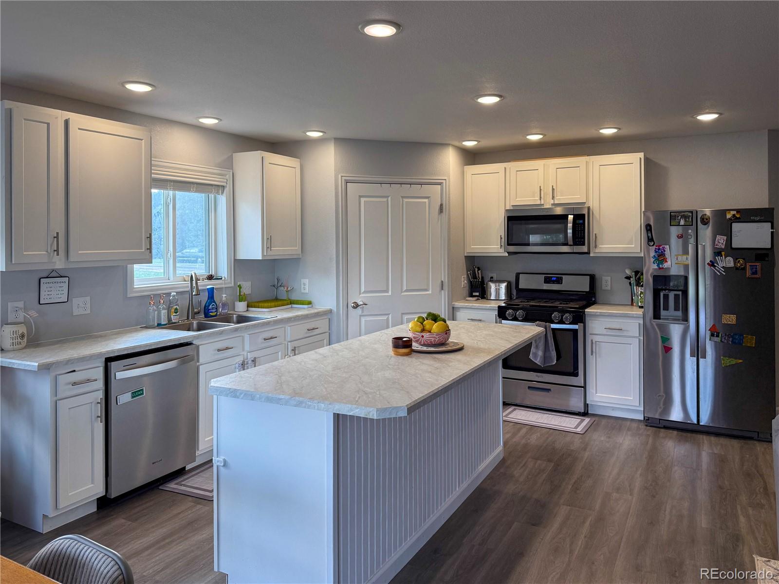 370 West 8th Street North, Unit A & B Cheyenne Wells, CO 80810 - Photo 29 of 47 a kitchen with kitchen island granite countertop a stove top oven a sink a counter space and cabinets
