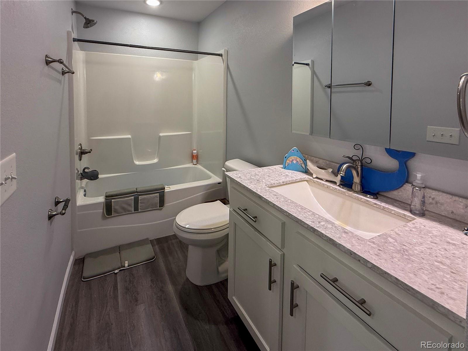 370 West 8th Street North, Unit A & B Cheyenne Wells, CO 80810 - Photo 37 of 47 a bathroom with a granite countertop sink a toilet a mirror and shower