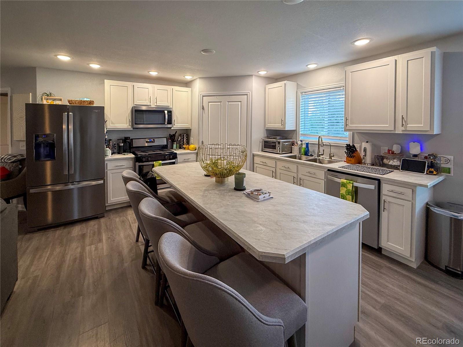 370 West 8th Street North, Unit A & B Cheyenne Wells, CO 80810 - Photo 6 of 47 a kitchen with stainless steel appliances granite countertop a sink dishwasher a refrigerator a stove and white cabinets with wooden floor
