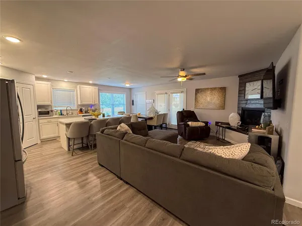 a living room with furniture kitchen view and a refrigerator
