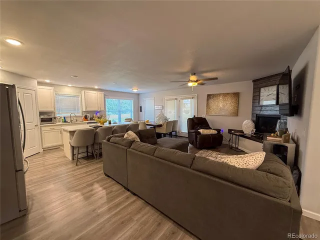 a living room with furniture kitchen view and a refrigerator