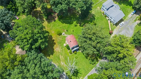 an aerial view of residential house with outdoor space and trees all around