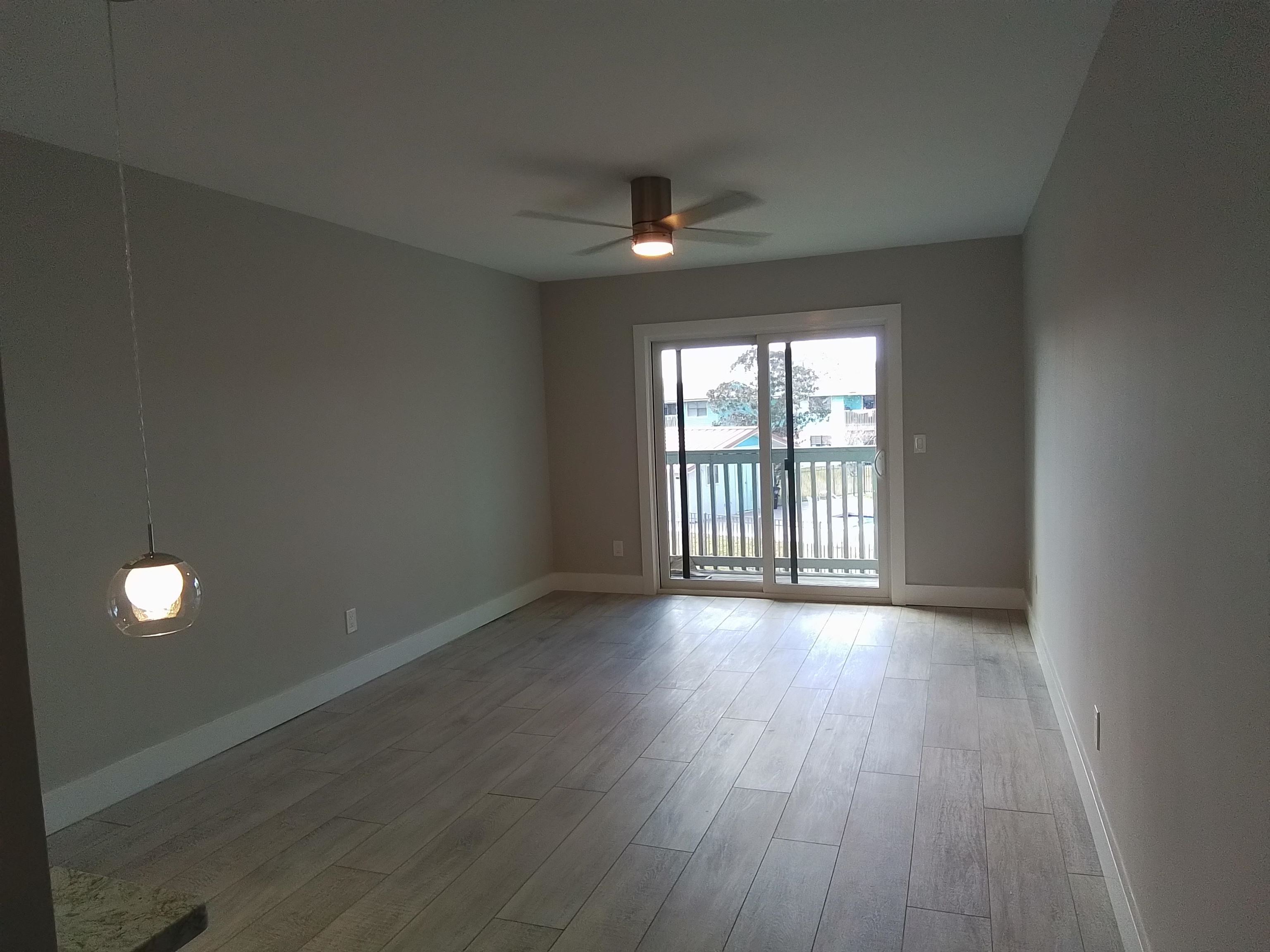 650 West Pope Road, Unit 244 St. Augustine, FL 32080 - Photo 8 of 27 an empty room with wooden floor and windows