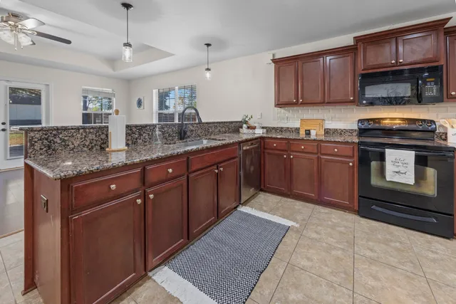 a bathroom with a granite countertop sink a mirror and a toilet