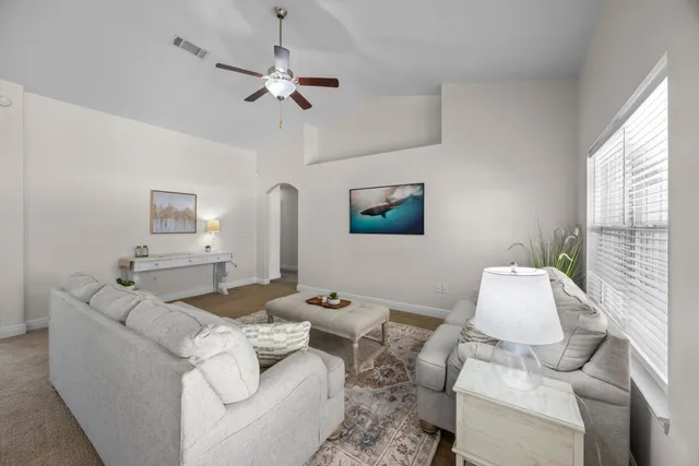 a living room with furniture a fireplace and a chandelier