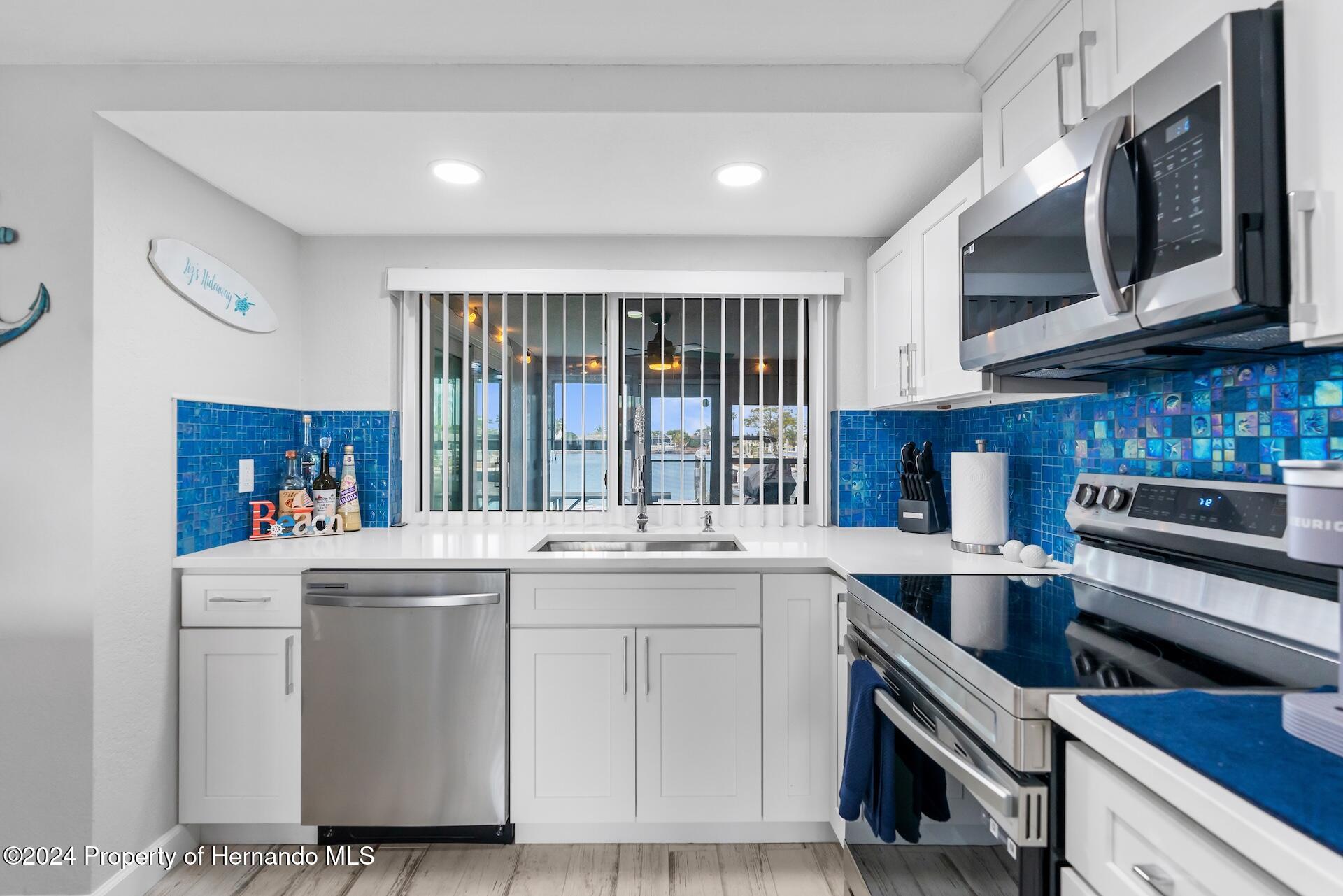 12535 3rd Isle Hudson, FL 34667 - Photo 15 of 46 a kitchen with a stove microwave and sink
