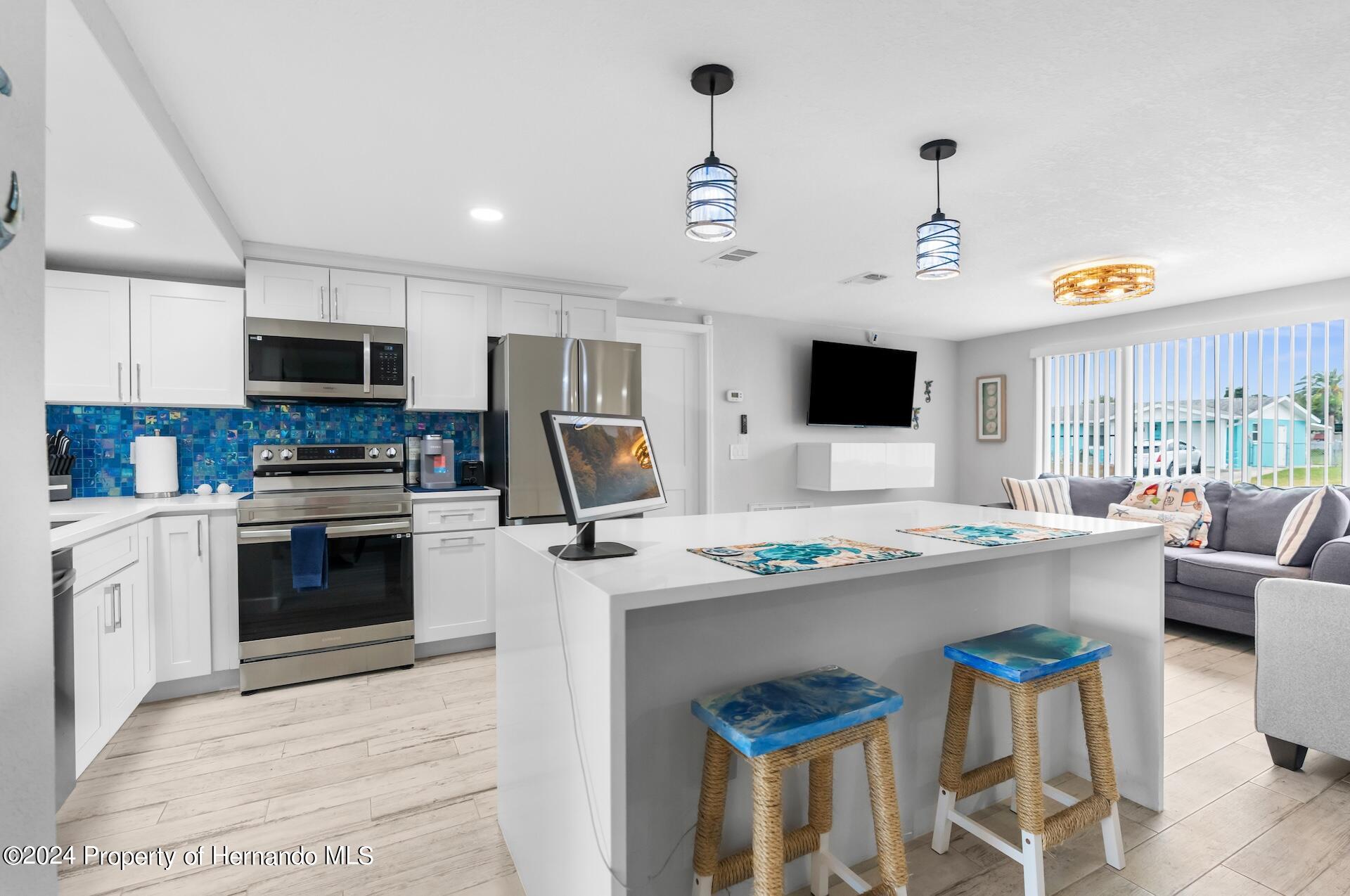 12535 3rd Isle Hudson, FL 34667 - Photo 20 of 46 a kitchen with stainless steel appliances a stove a sink and a refrigerator