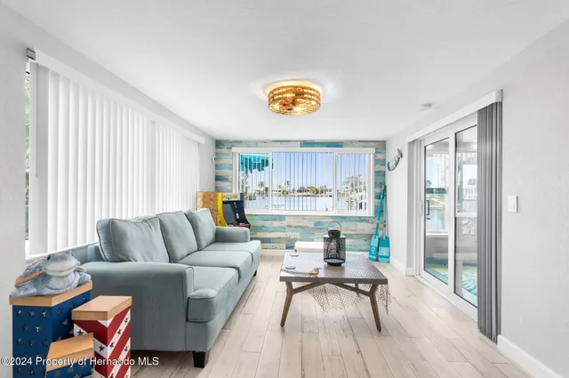 a living room with furniture a chandelier and a large window