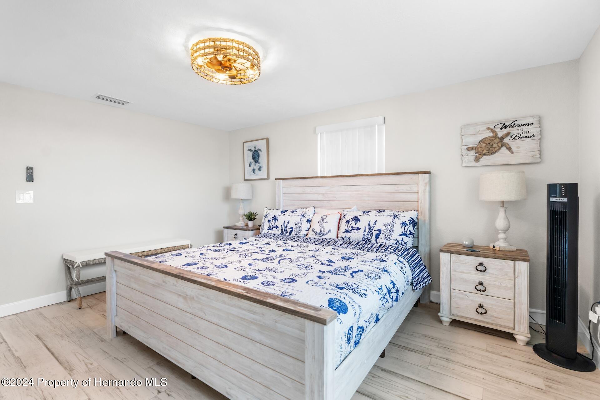 12535 3rd Isle Hudson, FL 34667 - Photo 28 of 46 a bedroom with a bed and a lamp on dresser