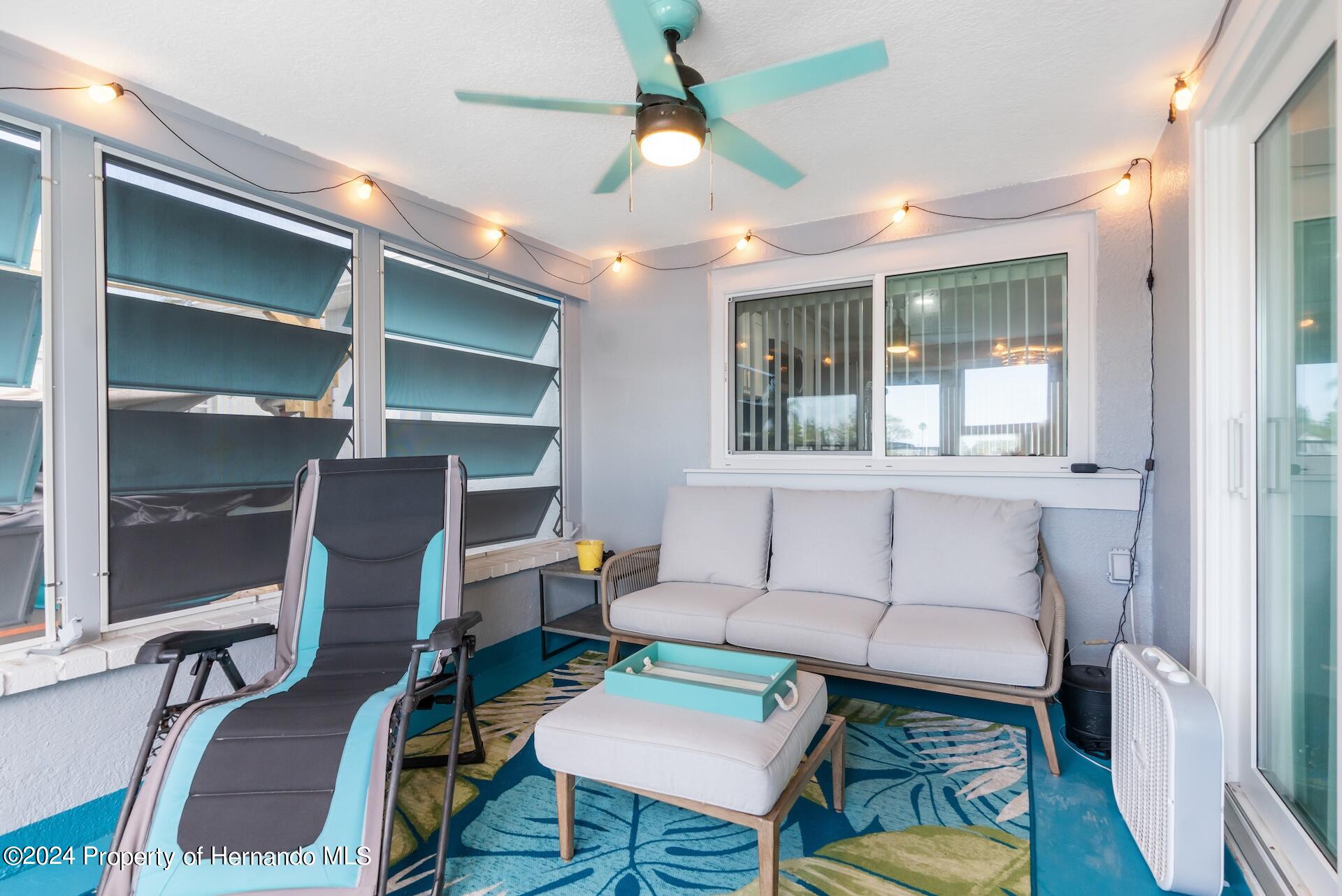 12535 3rd Isle Hudson, FL 34667 - Photo 35 of 46 a living room with furniture a chandelier and a piano