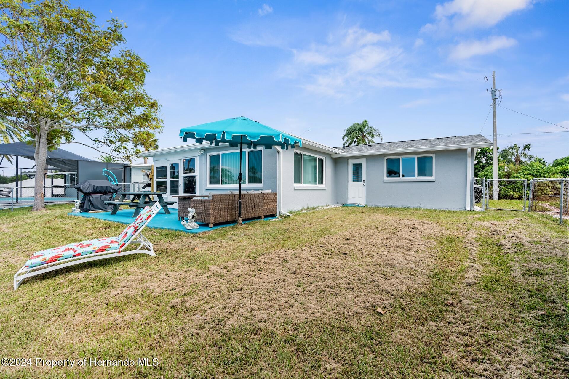 12535 3rd Isle Hudson, FL 34667 - Photo 43 of 46 a front view of a house with a yard table and chairs
