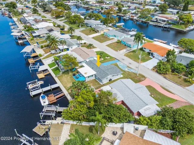 an aerial view of residential houses with outdoor space and lake view