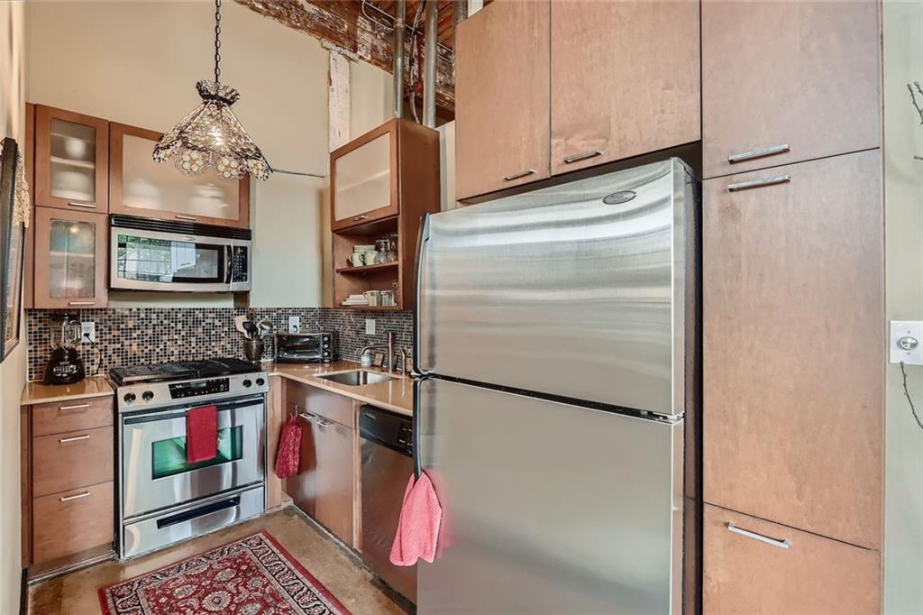 170 Boulevard Southeast, Unit 101F Atlanta, GA 30312 - Photo 4 of 11 a kitchen with stainless steel appliances granite countertop a refrigerator a stove and a sink with wooden floor