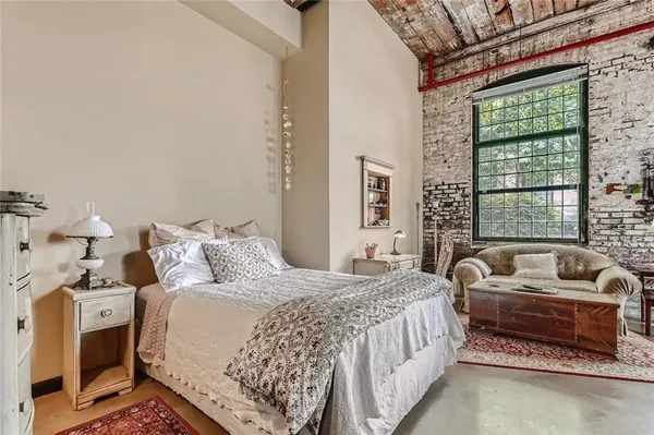 a bedroom with bed couch and window