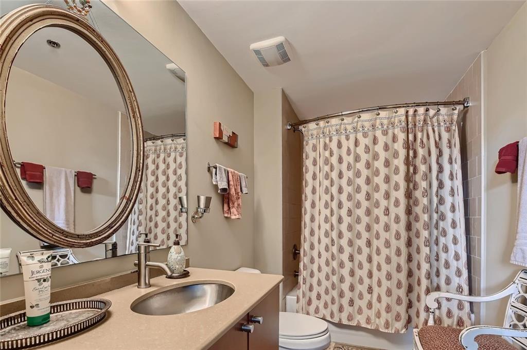 170 Boulevard Southeast, Unit 101F Atlanta, GA 30312 - Photo 7 of 11 a bathroom with a sink a toilet and a mirror
