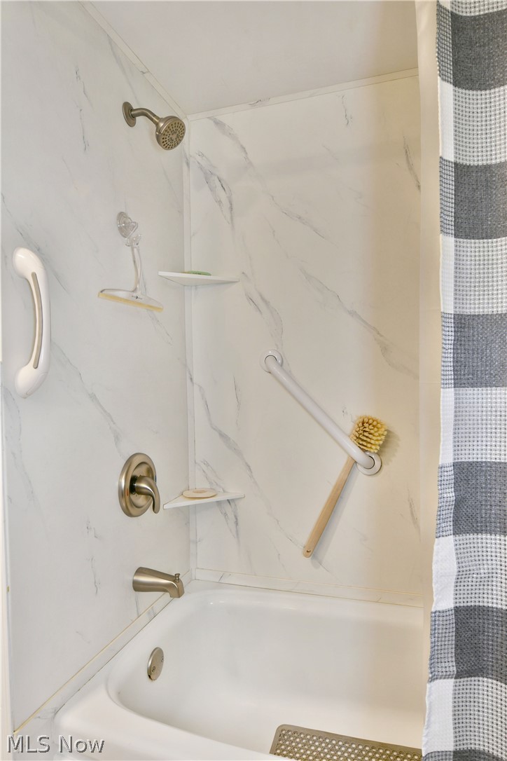 8683 King Graves Road Northeast Warren, OH 44484 - Photo 38 of 50 Bathtub and shower combination featuring a marble-patterned surround