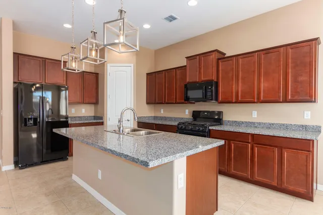 a kitchen with stainless steel appliances granite countertop a sink stove and refrigerator