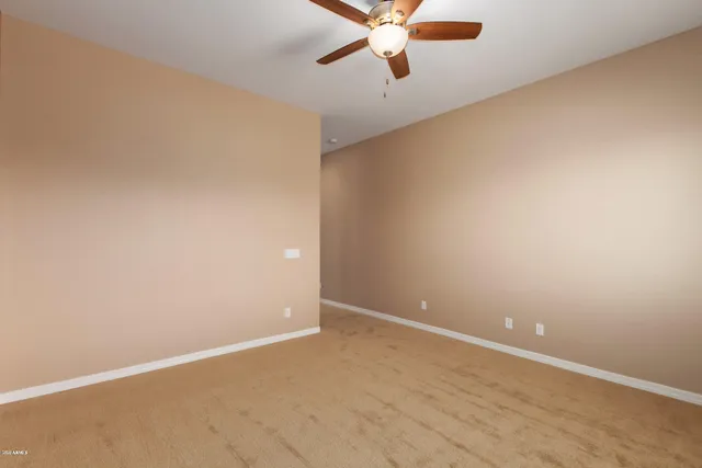 an empty room with a window and a ceiling fan
