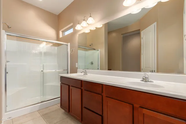 a bathroom with a double vanity sink mirror and shower