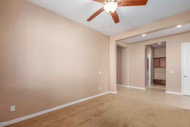 an empty room with chandelier fan